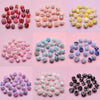 Assortment of colorful handmade acrylic flower beads for jewelry making in various shades and textures.