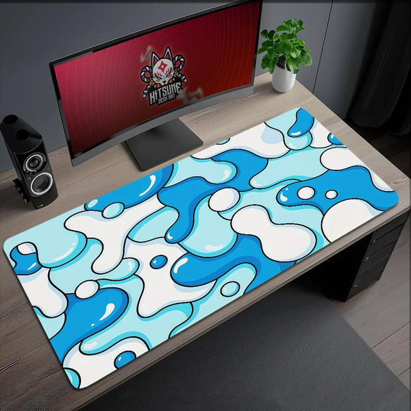 A blue and white wave pattern mouse pad placed on a wooden desk next to a computer monitor.