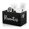 A black wooden storage box with dividers holding several white remote controls and small electronic devices.