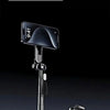 A black magnetic pocket selfie stick is shown standing on a dark surface.