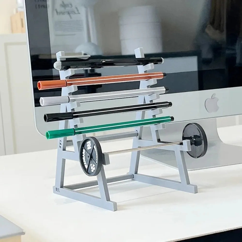 A silver barbell rack desk organizer holding various colored bars and a pen holder.