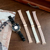 A black resin beaded watch with a gold-tone watch band is displayed next to three other watch bands.