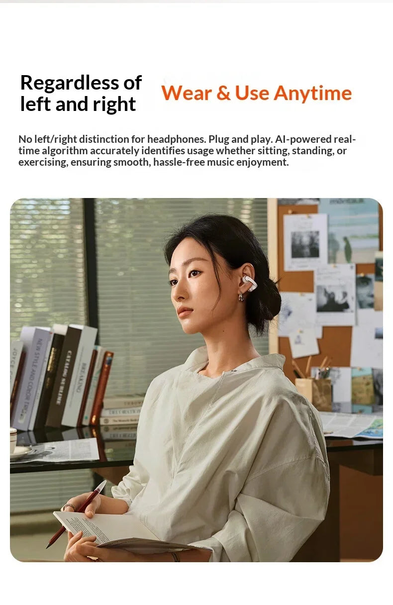 A woman wearing a light beige hoodie is looking at a notebook while using Bluetooth headphones.