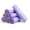 Rolls of purple waterproof self-adhesive courier mailer bags stacked and lying on a white surface.