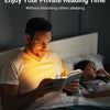 A man is reading a book in bed with a USB rechargeable LED book reading light.