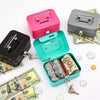 A collection of pink and gray steel cash boxes with key locks and a green box containing stacked coins and bills.