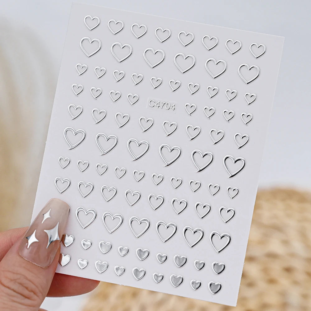 A sheet of metallic 3D heart and star nail art stickers for decorative use.