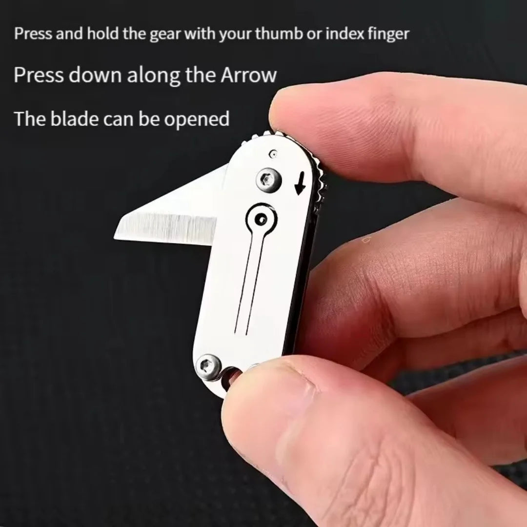 A hand presses down on the arrow of a compact stainless steel pocket knife to open the blade.