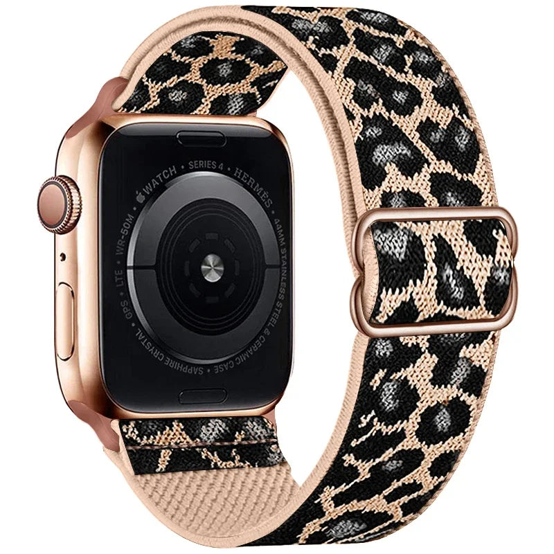 A close-up of a rose gold Apple Watch with a leopard print nylon band.