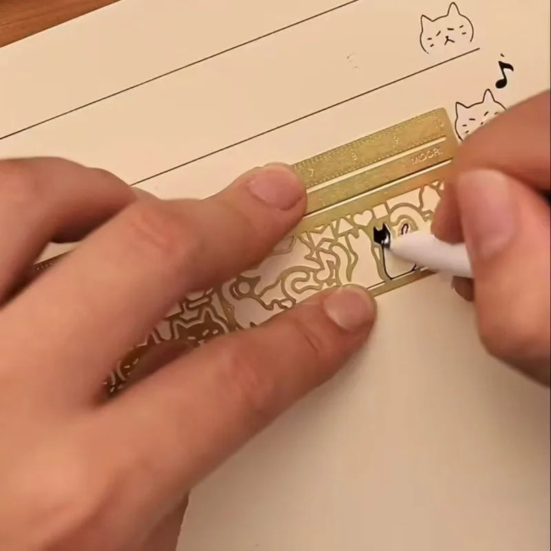 Manos usando una regla marcador metálica con diseño de gato para marcar una página.