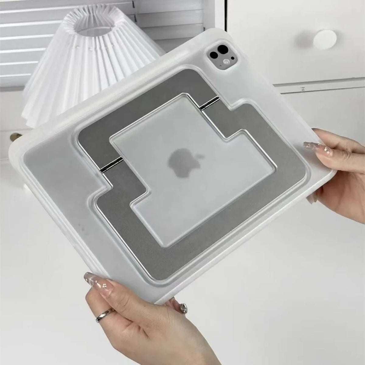 A white protective case for a tablet or iPad is shown being held, featuring a stand and a clear cover.