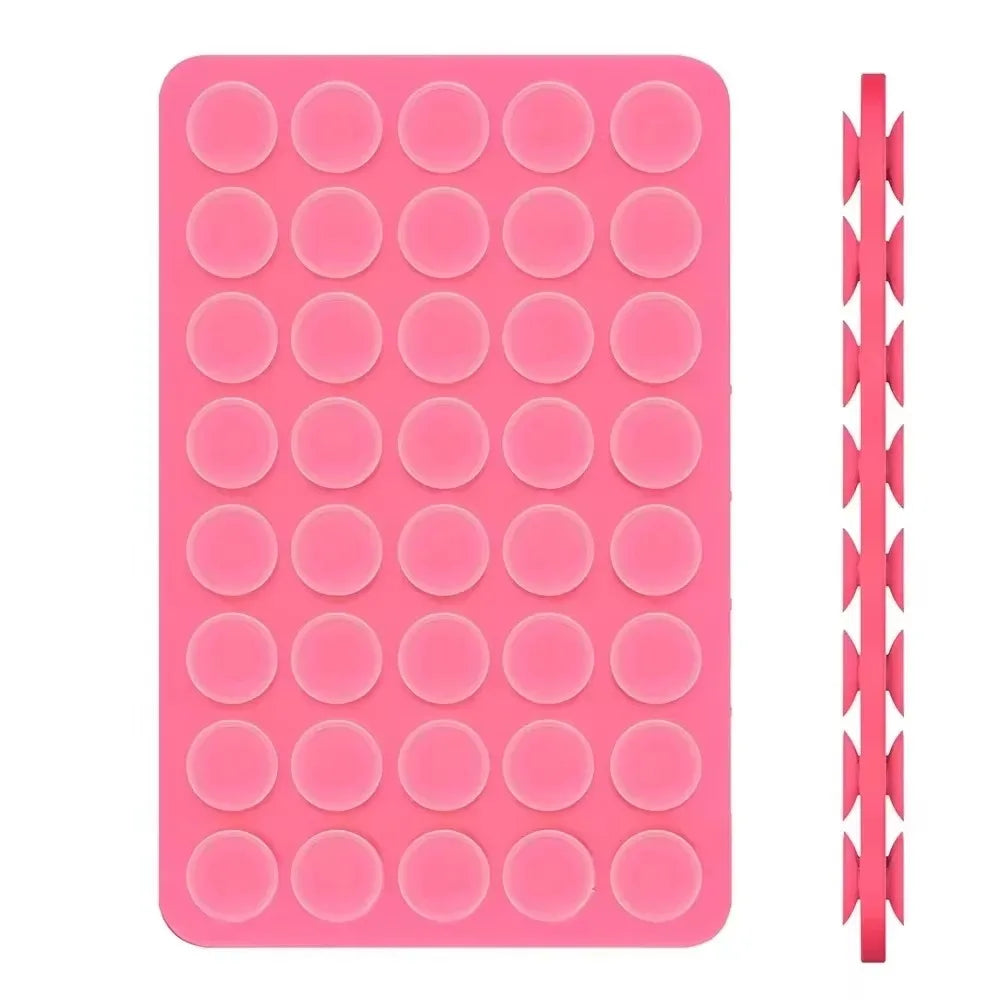 A pink double-sided silicone phone mount grip with multiple circular holes.