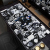 An oversized black and white graphic mouse pad featuring Death Note characters and themes on a wooden desk surface.