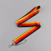 A black and yellow striped vintage cassette tape lanyard with a metal clip.