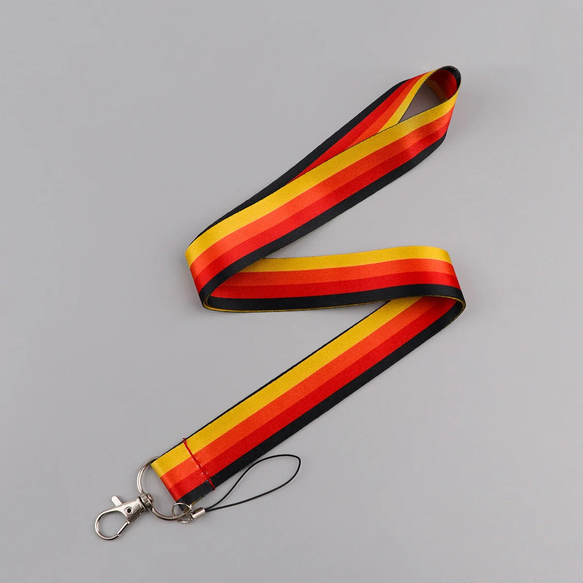 A black and yellow striped vintage cassette tape lanyard with a metal clip.
