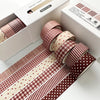 A set of red plaid and polka dot washi tape rolls displayed in a box for crafting and journaling.