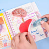 Hands are applying a roll of pink double-sided adhesive tape onto a notebook page.