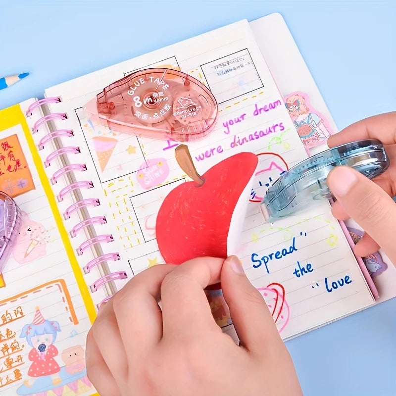 Hands are applying a roll of pink double-sided adhesive tape onto a notebook page.