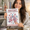 A smiling woman holds an Anatomy Labeling Workbook with a diagram of the lungs and respiratory system.