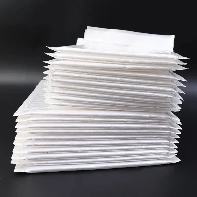 Une pile d'enveloppes de transport et de cadeaux blanches et rembourrées haut de gamme.