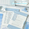 A light blue A4 leather clipboard with a magnetic closure and contrast stitching displaying lined paper.