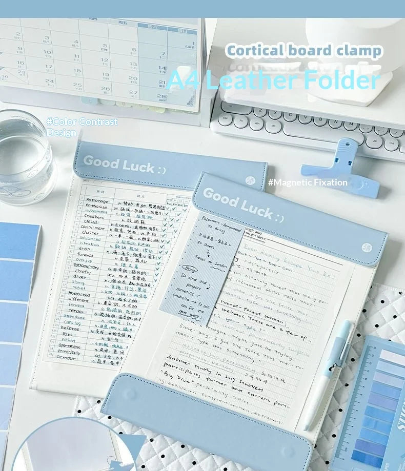 A light blue A4 leather clipboard with a magnetic closure and contrast stitching displaying lined paper.
