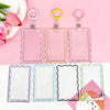 A set of clear acrylic card holders with colorful borders and keychain rings displayed on a pink background.