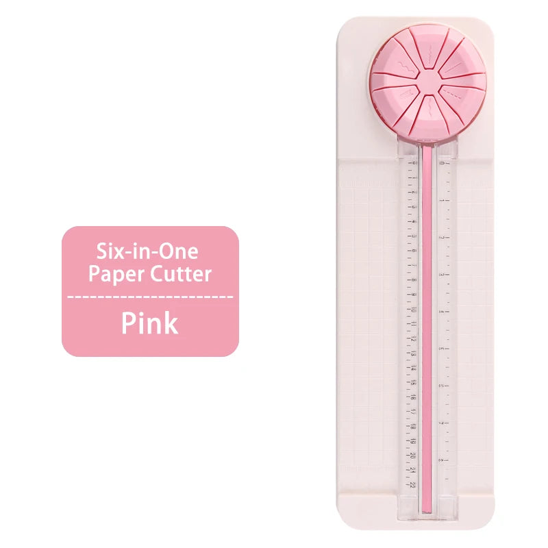 Pink six-in-one paper cutter with a rotary blade and ruler markings.