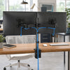 A heavy duty dual monitor desk mount holding two computer monitors on a wooden desk.