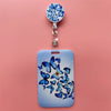 A light blue card holder clip featuring a design of blue butterflies on the surface.