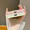 A hand holds a pink and white magnetic ring stand shockproof phone case with camera protection.