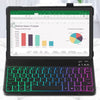 A laptop displaying an online sales tracker spreadsheet on the screen with a rainbow backlit keyboard case visible below.