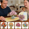 A close-up of a 3D pop-up cherry blossom bouquet card displayed on a yellow card, showing various floral arrangements.