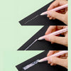 A hand uses a glue pen to apply white glue dots on a black surface.