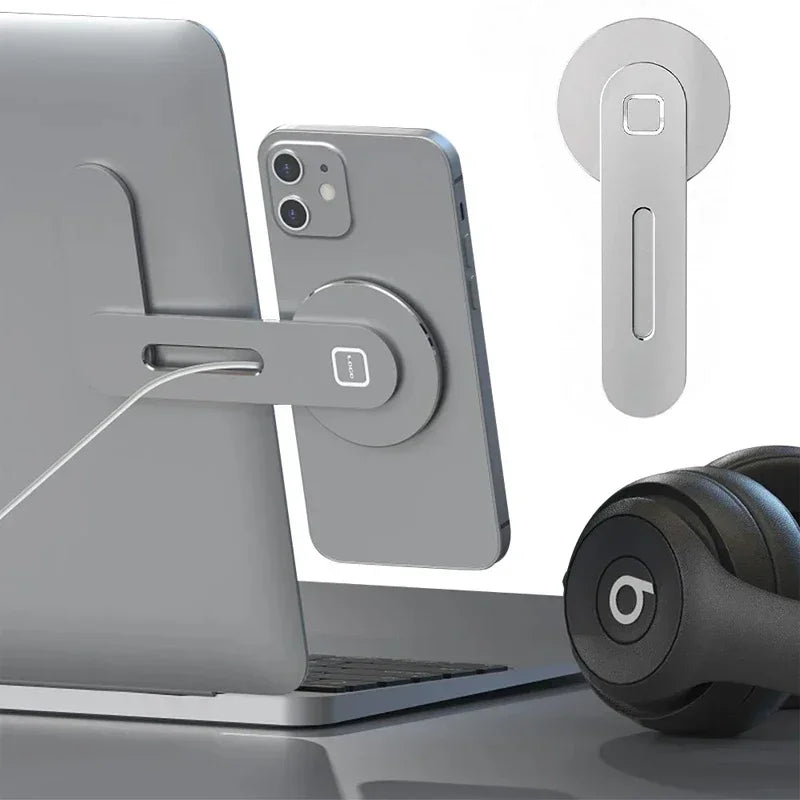 A magnetic phone holder attaches to a laptop, holding a smartphone and a pair of headphones.