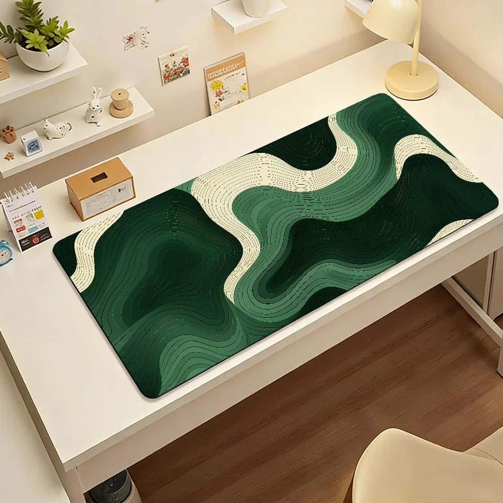 A dark green and cream abstract wave mouse pad displayed on a white desk.
