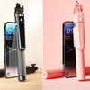 A pink 360 degree rotation selfie stick with a smartphone attached and a Bluetooth remote.