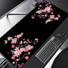 Schwarze Gaming-Mauspad mit rosa Kirschblüten-Blumenmuster auf der Oberfläche.