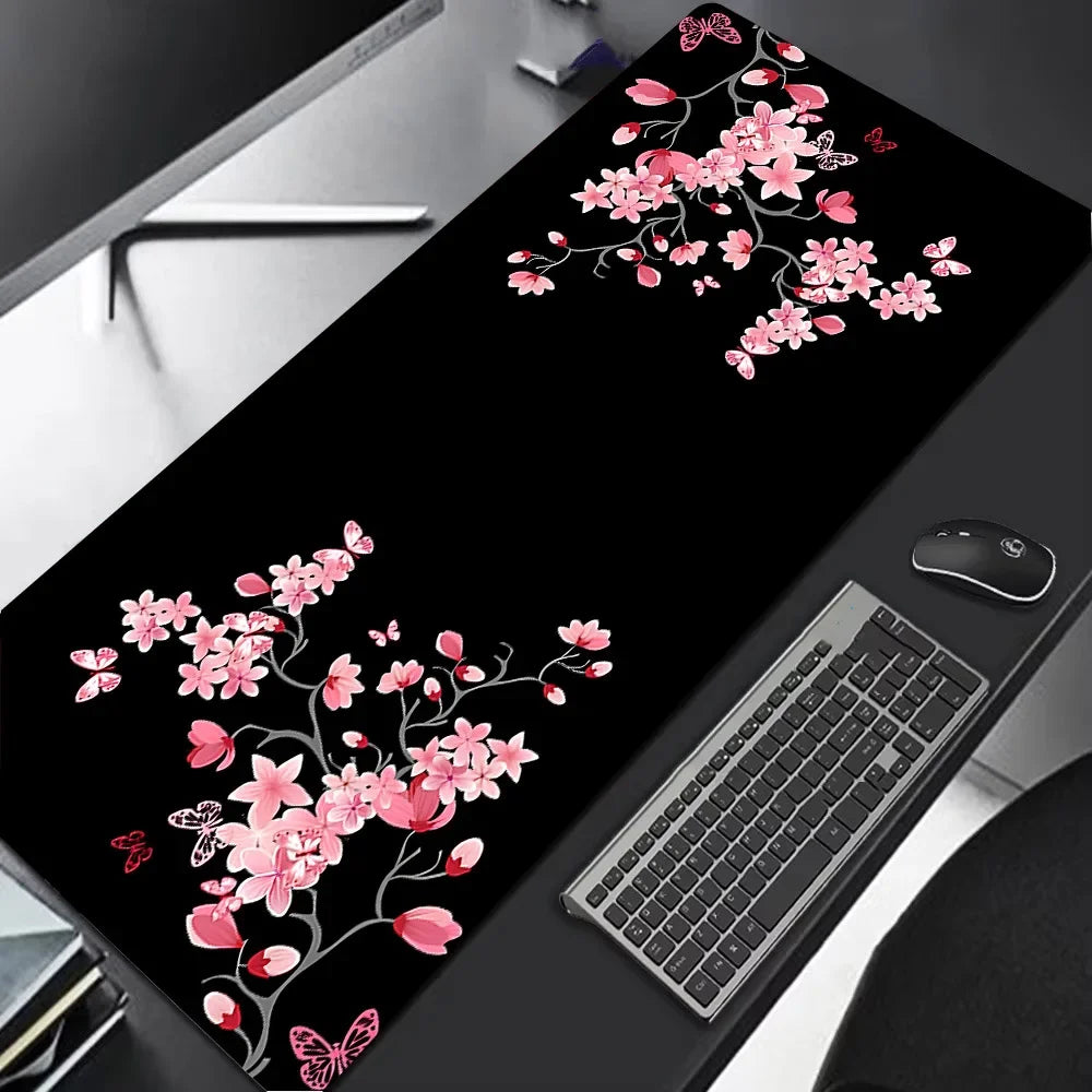 Schwarze Gaming-Mauspad mit rosa Kirschblüten-Blumenmuster auf der Oberfläche.