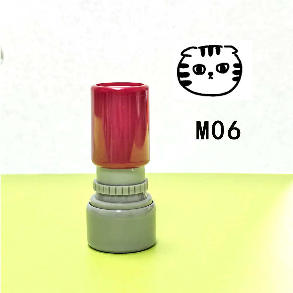 A teacher stamp with a cat pattern, featuring a red top and a gray base, is shown against a light background.