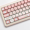 A close-up view of light pink and white themed PBT keycaps for a mechanical keyboard.