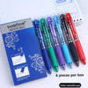 A box containing a set of six black, blue, green, purple, and red erasable retractable gel pens is shown next to a notepad.