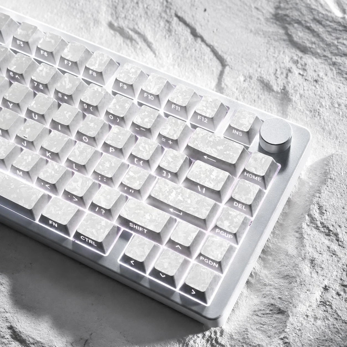 Nahaufnahme von weißen Kohlenstoff-Keycaps auf einer strukturierten Oberfläche.