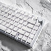 Nahaufnahme von weißen Kohlenstoff-Keycaps auf einer strukturierten Oberfläche.