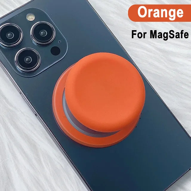 Orange MagSafe phone grip stand with silicone cover shown on a dark blue smartphone.
