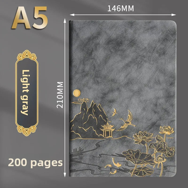 A luxury gray notebook with gold foil illustrations of mountains, pagodas, and flowers.