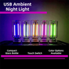 A set of five glass light bulbs with various colored LED lights displayed on a dark surface.