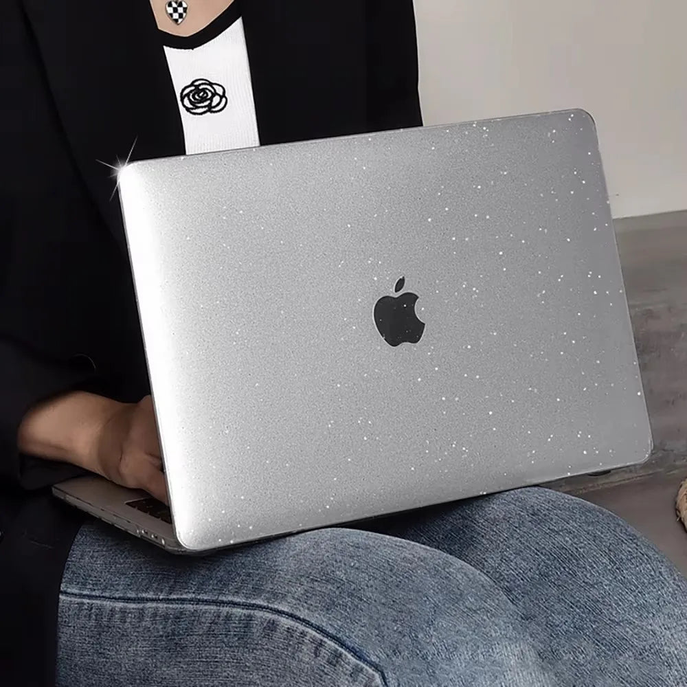 Una persona sostiene una MacBook plateada con una funda protectora sobre su regazo.