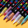 A collection of black paint markers in various colors, including purple, orange, and green, displayed diagonally.