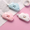 Two portable utility knives in light blue and pink are shown resting on a piece of paper.